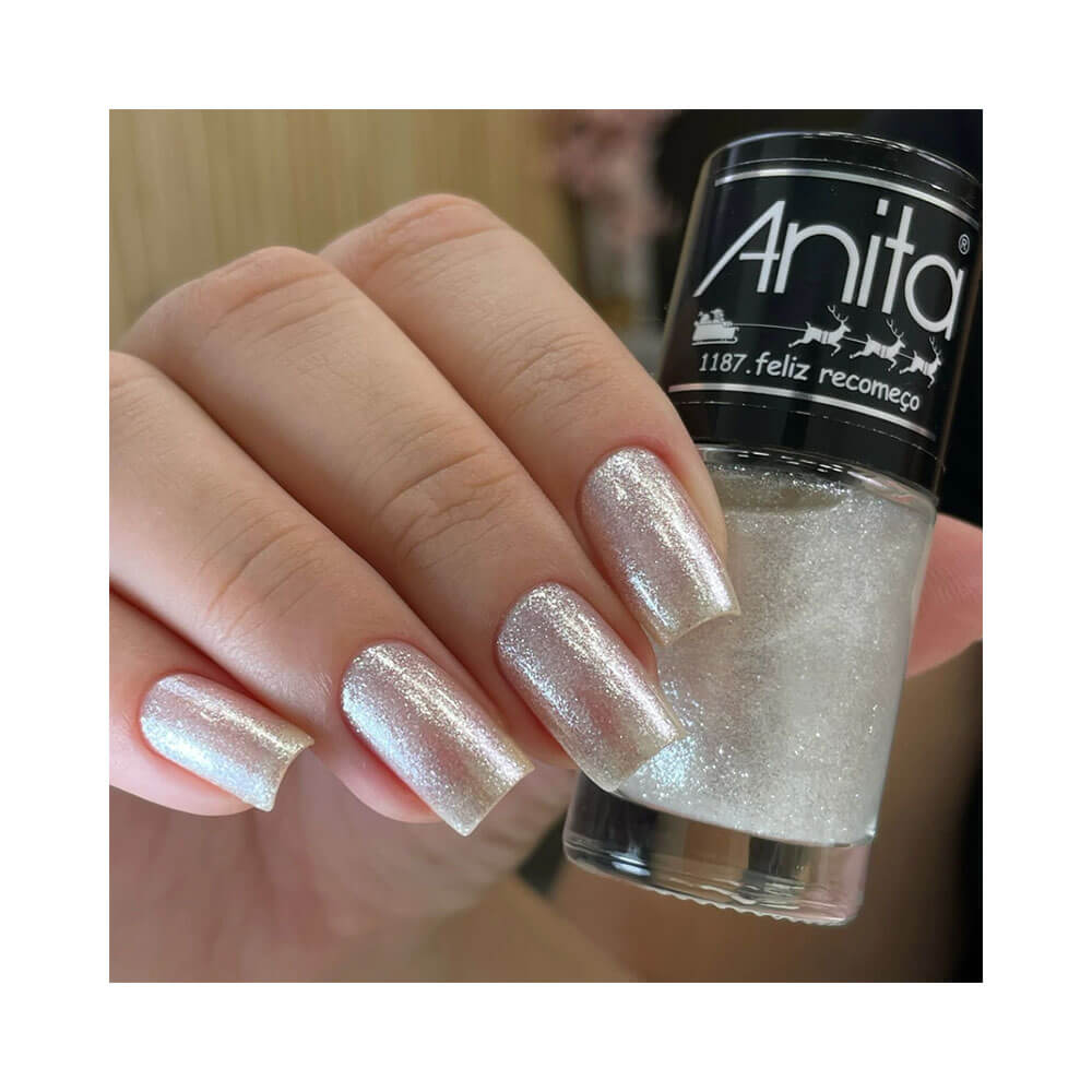 Mão feminina segurando o esmalte Anita Tempo de Celebrar Feliz Recomeço com unhas pintadas na mesma cor