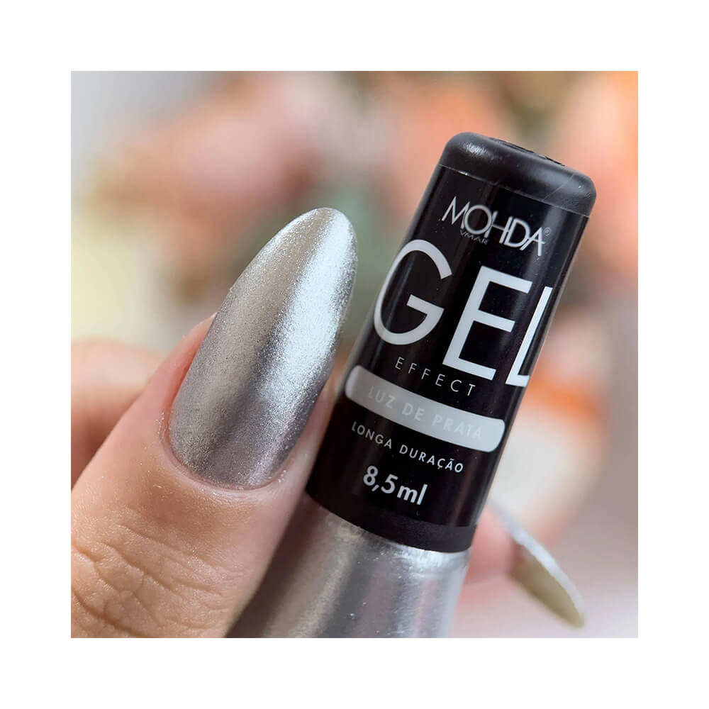 Mão segurando frasco de esmalte Mohda Efeito Gel Luz de Prata com unha pintada