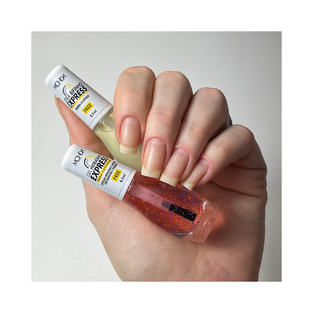 Mão segurando frascos do Esmalte Mohda Tratamento Zera Bifinho Express, mostrando aplicação em unhas naturais