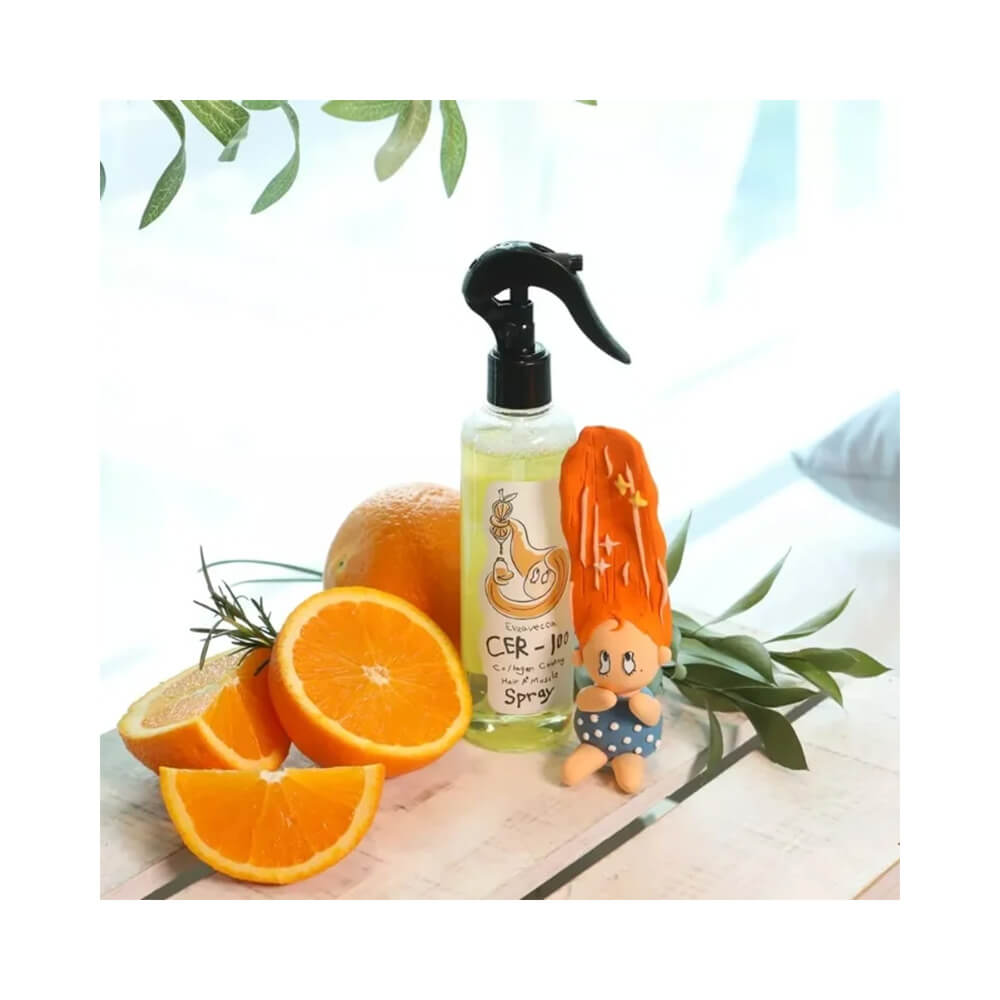 Hair Spray Elizavecca Cer 100 Collagen Coating 250ml sobre superfície branca com fatias de laranja e planta verde ao fundo.