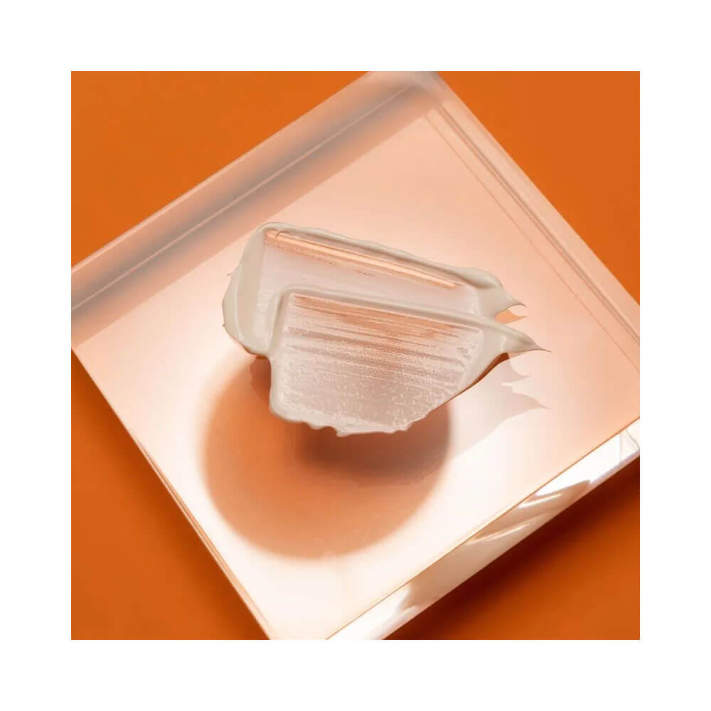 Textura cremosa do Protetor Solar Sunless FPS 50 sobre fundo laranja