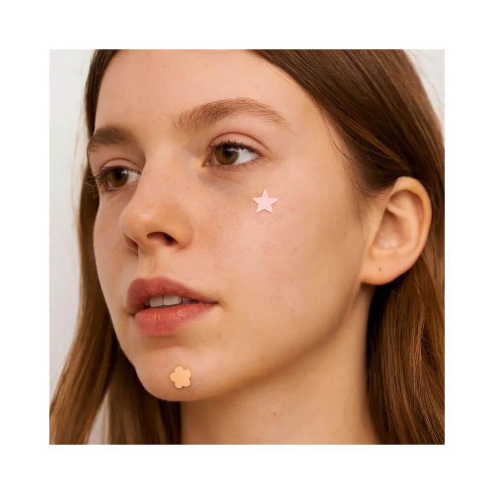 Mulher com adesivos secativos Ricca para acne em formato de flor e estrela no rosto
