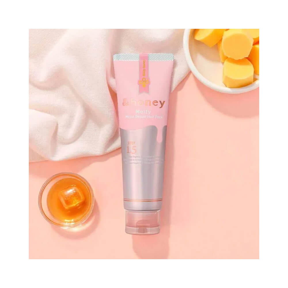 Produto Tratamento Hidratante &Honey Melty Moist Repair Hair Pack 180g sobre fundo rosa claro com mel e manteiga ao lado
