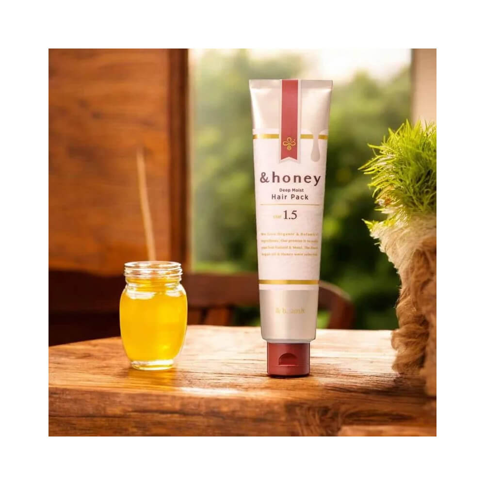 Máscara Capilar &Honey Deep Moist Hair Pack 130g sobre superfície de madeira com pote de mel ao lado