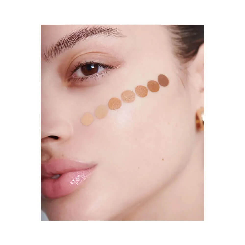 Rosto feminino com diferentes tons do corretivo Mari Maria Cover Up aplicados na bochecha