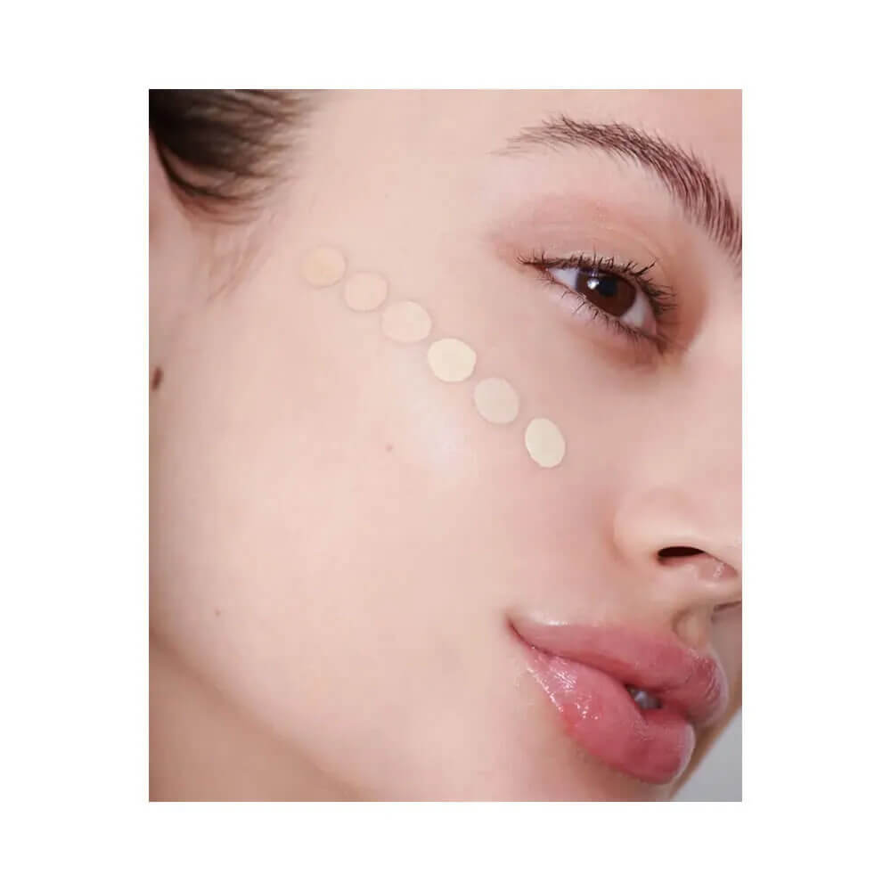 Close no rosto com amostras do corretivo Mari Maria Cover Up MM02 em tons de bege claro