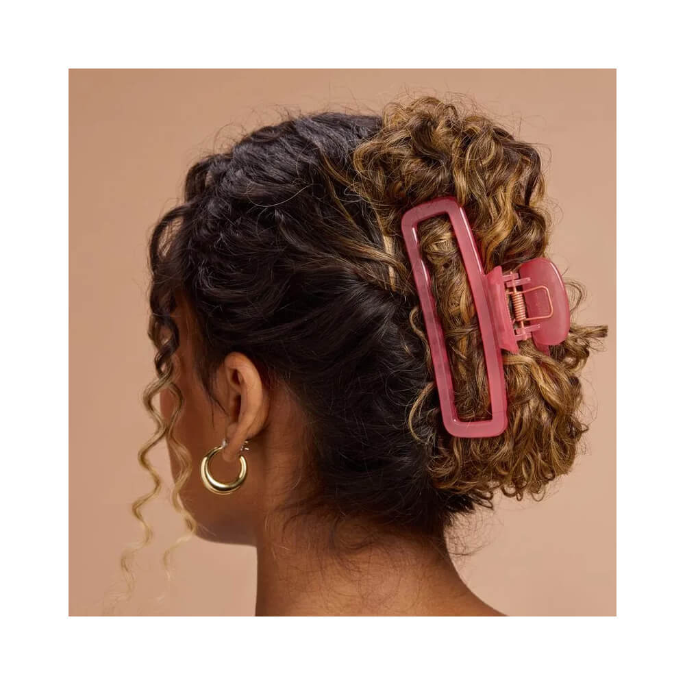 Mulher com cabelo cacheado preso por piranha vermelha translúcida Proart Candy