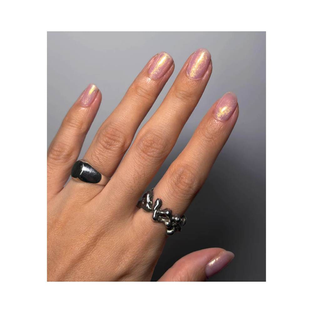 Mão feminina com unhas pintadas com esmalte Dailus Top Chrome Gold Top, acabamento metálico dourado com brilho cromado