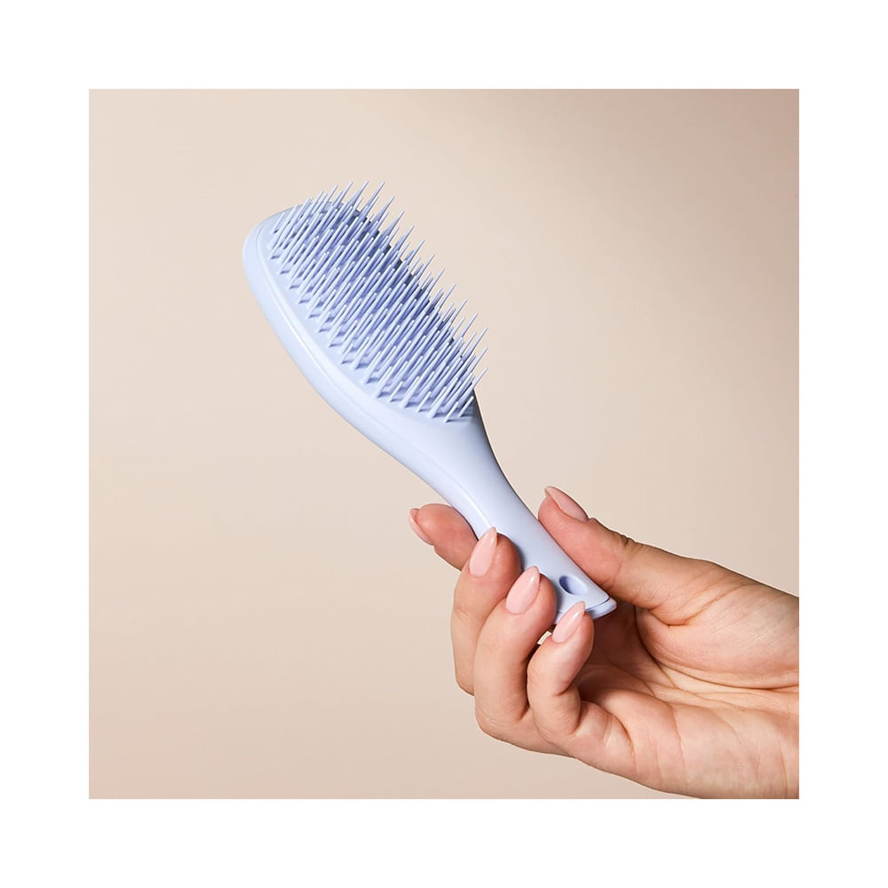 Escova Tangle Teezer Ultimate Detangler Mini Digital Lavander sendo segurada por mão feminina